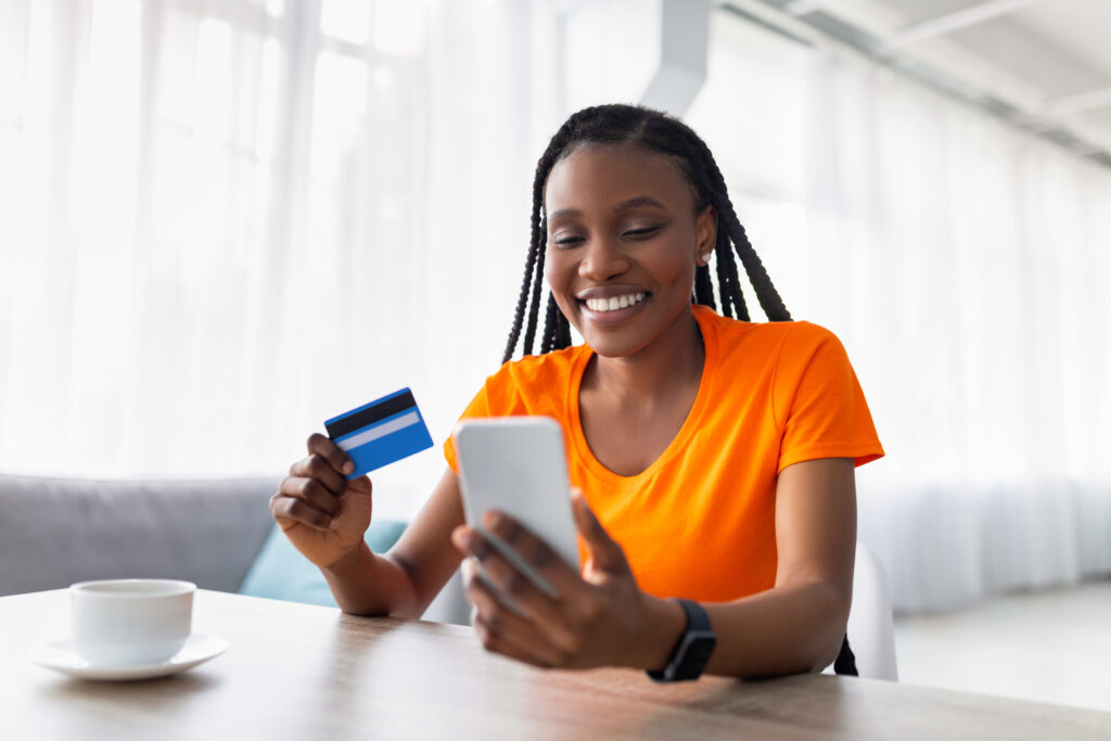 Frau mit Handy und Kreditkarte visualisiert Online-Shopping