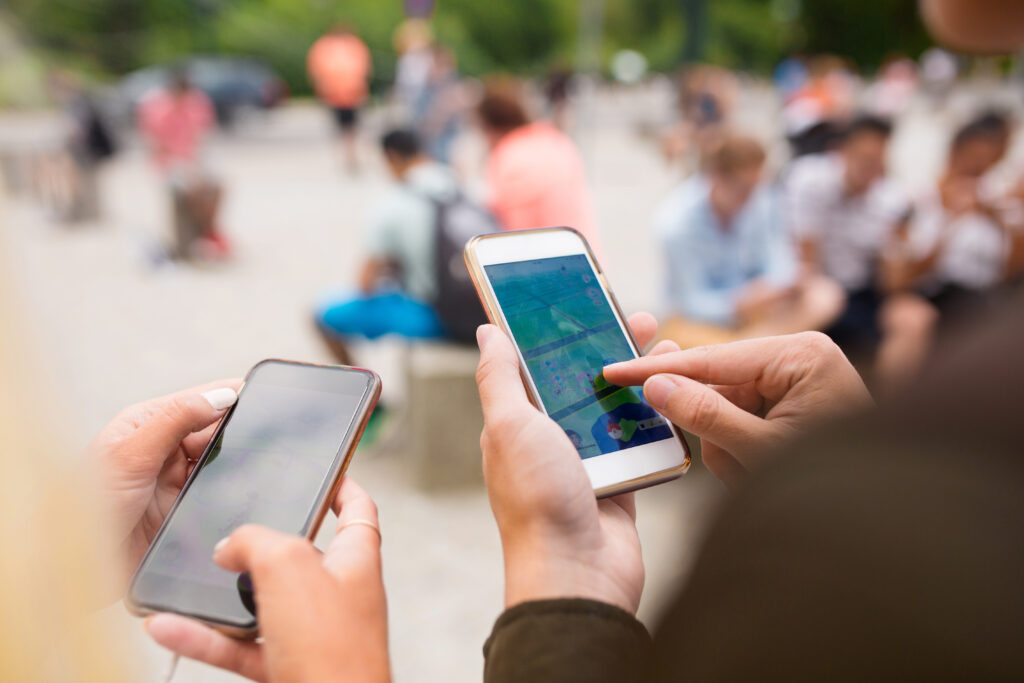 Two people using AR apps on their smartphones in the city.